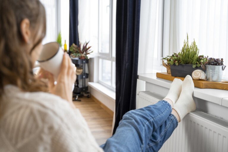 Woman sitting near radiator