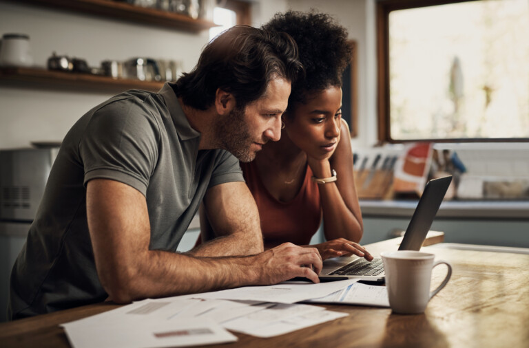 Couple looking at bills on laptop