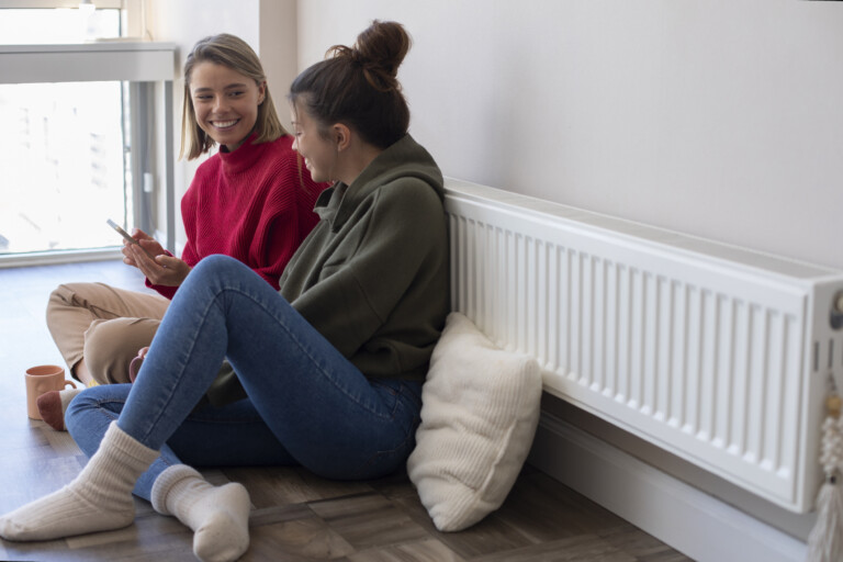 Friends next to a warm radiator