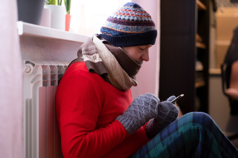 Man feeling cold at home with heating trouble