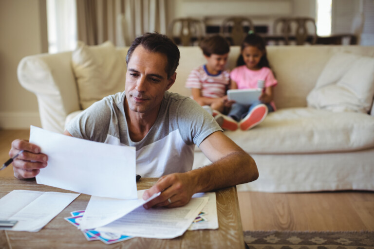 Man holding a bill in living room at home