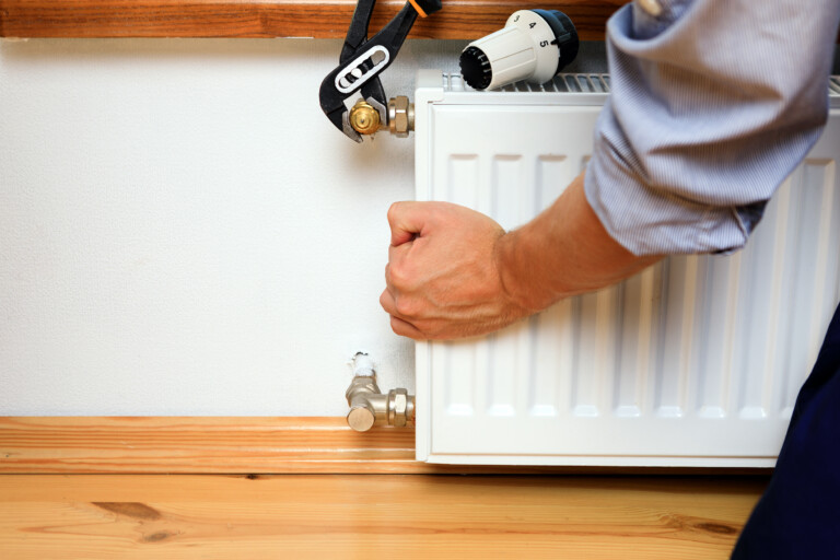 Repair heating radiator close-up. man repairing radiator with wrench. Removing air from the radiator